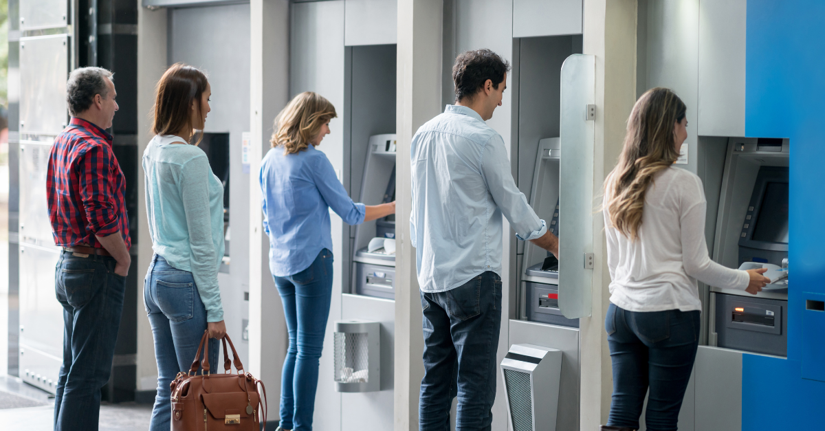 Row of people using ATM's