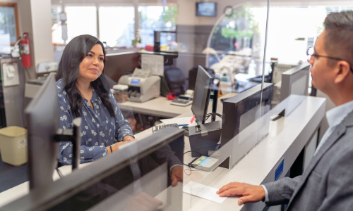 Bank teller helping out man at window 