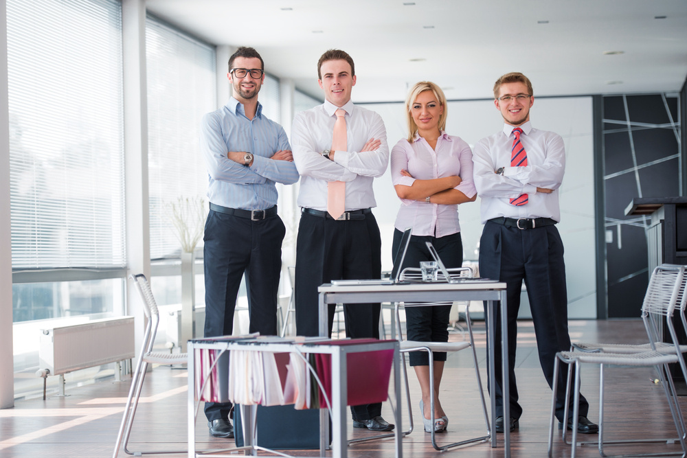 Business team of four posing in a modern office