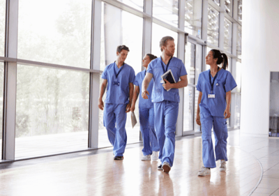 A group of doctors confidently walking through a well lit hallway