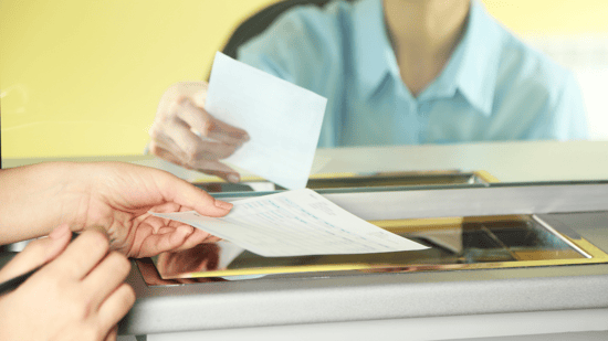 Bank teller handing cashier's check to customer 