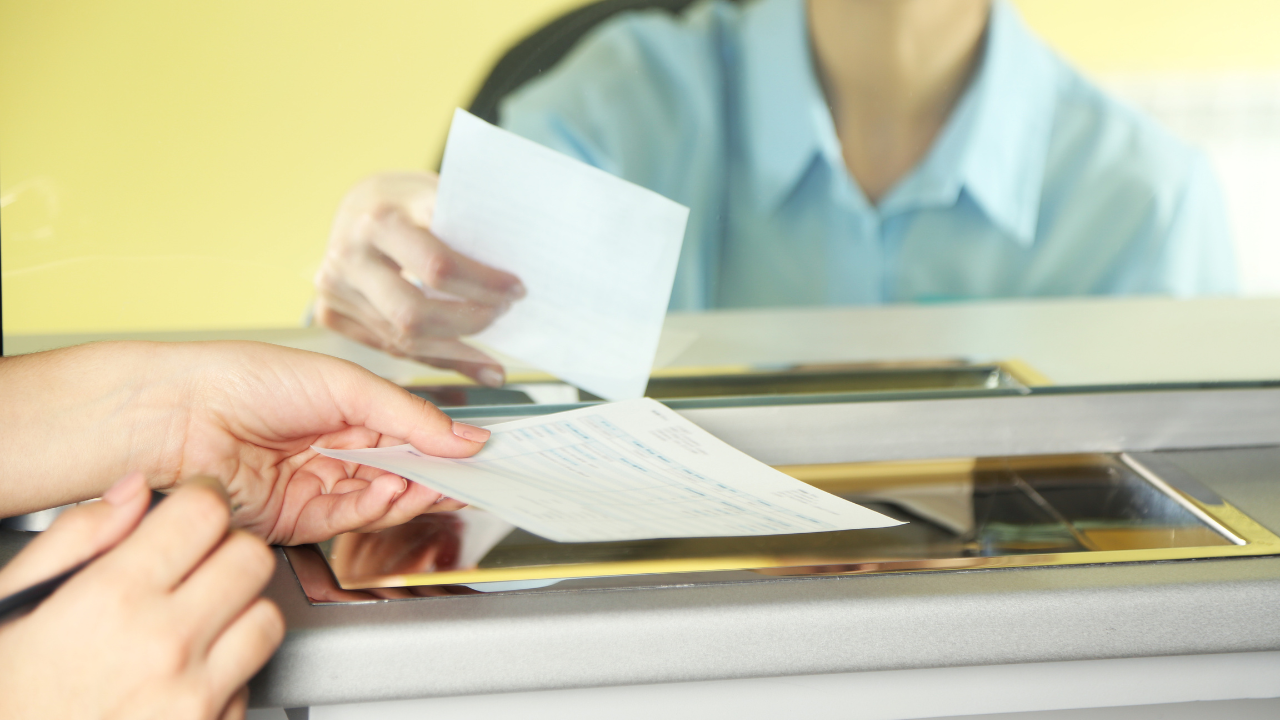 Bank teller handing cashier's check to customer 