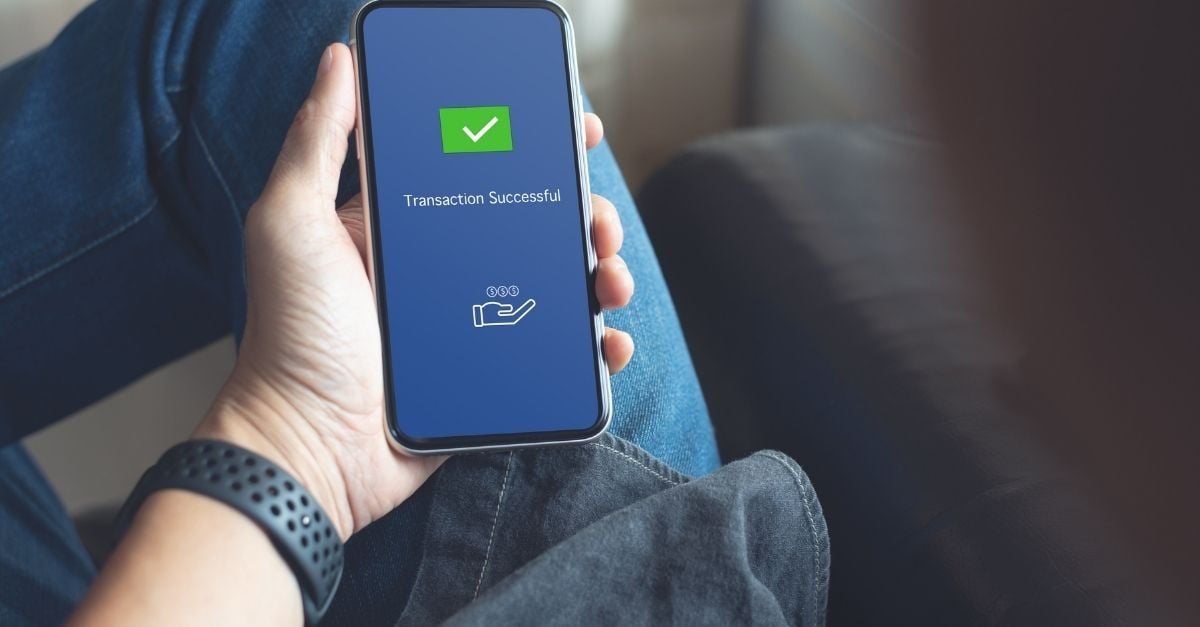 A man looking at his successful transaction on his smartphone 