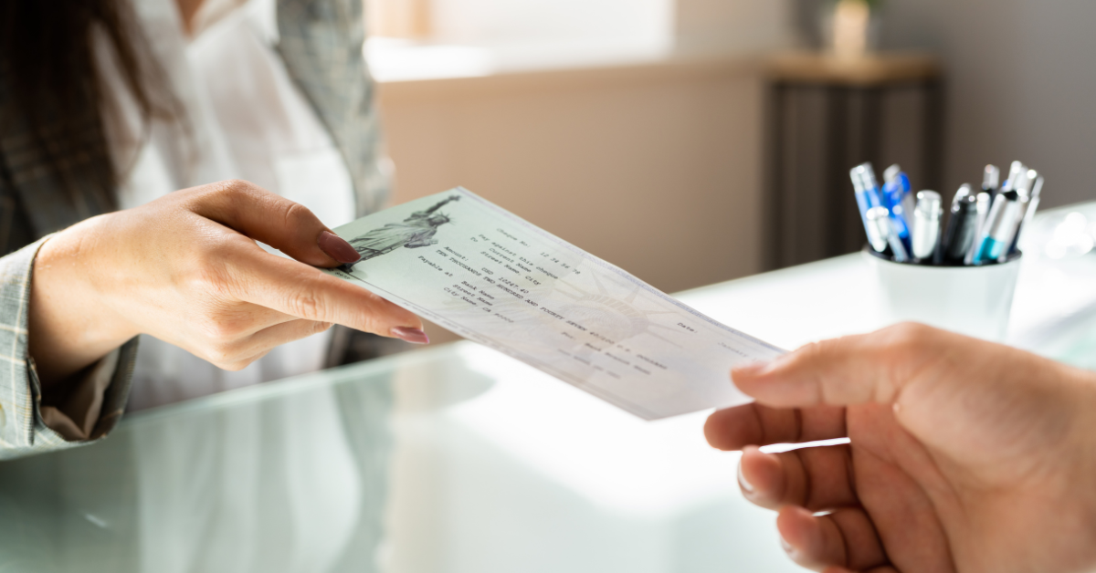 Bank teller handing cashier's check to customer 